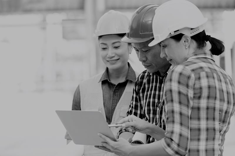 two female and one mail construction workers reviewing insurance