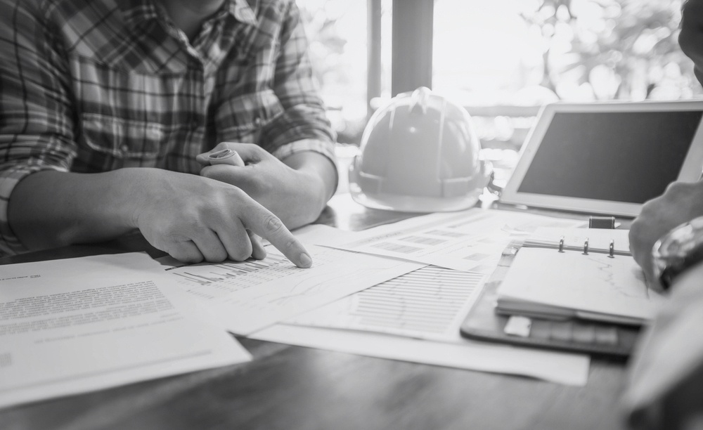 contractor sitting at desk and pointing at insurance papers