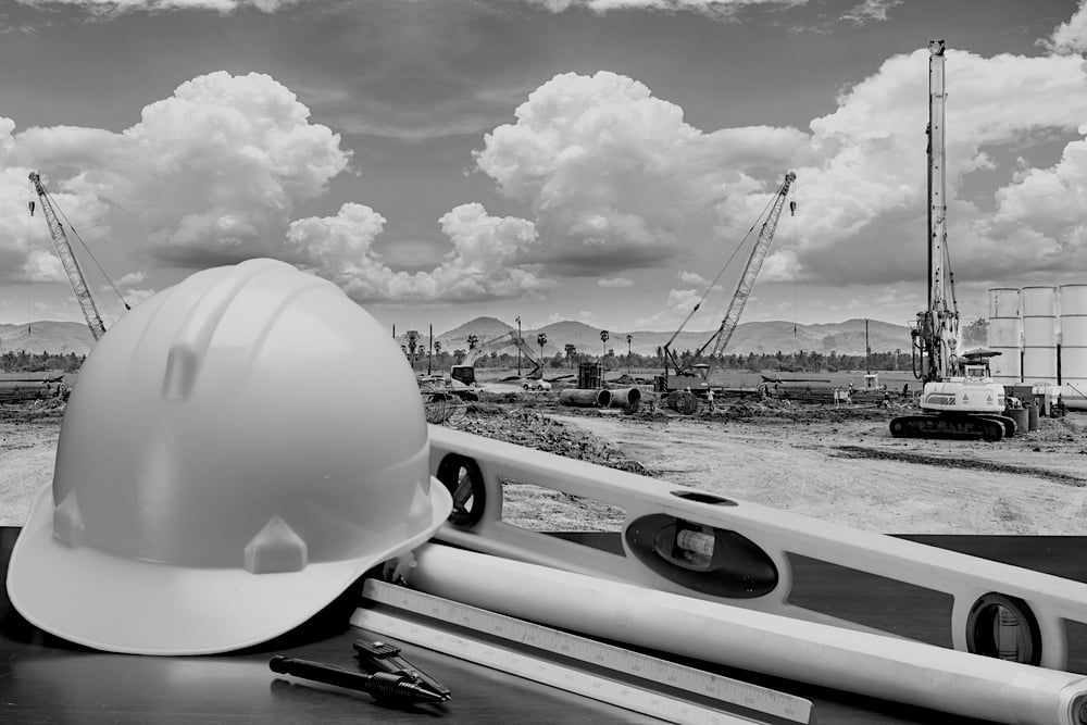 closeup of hardhat in front of busy construction jobsite