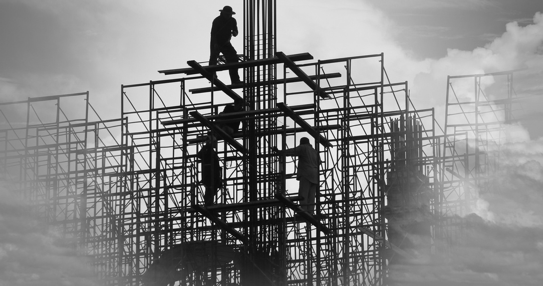 silhouette of construction workers on steel beams at jobsite 