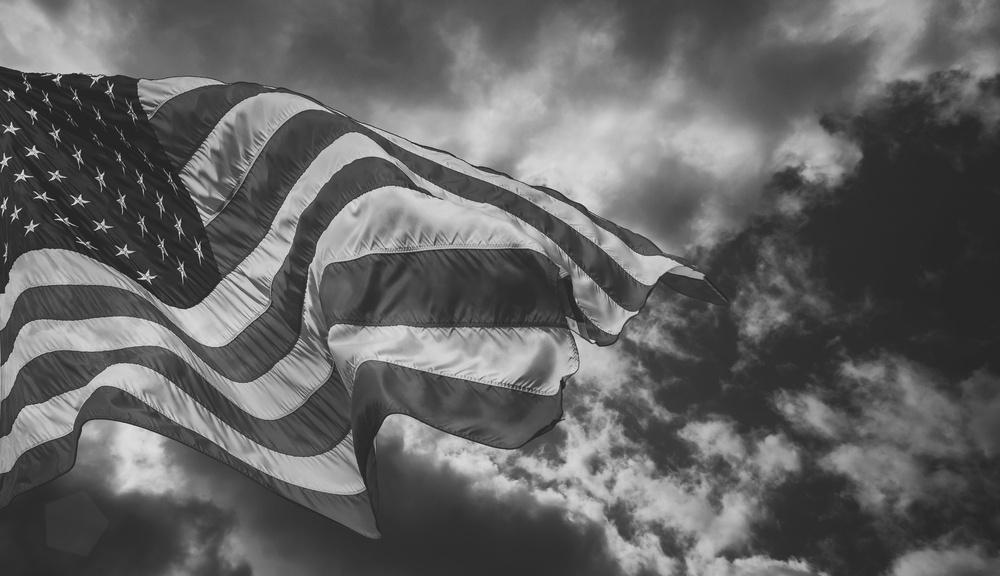 American flag blowing in the wind in a cloudy sky
