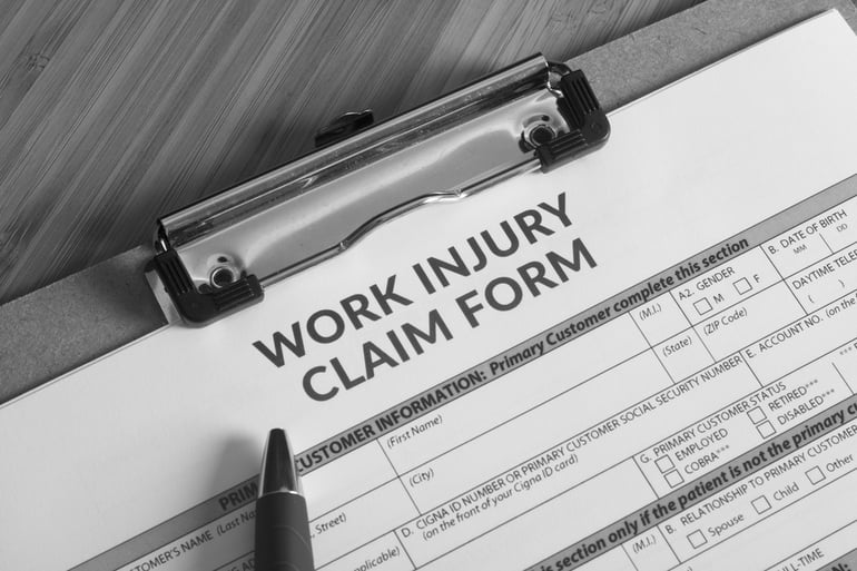 work injury claim form on desk with pen