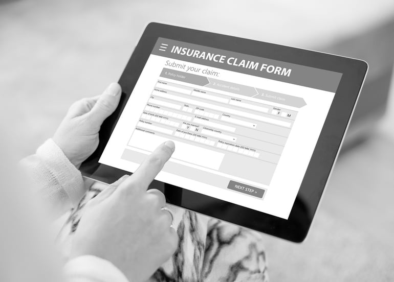 person holding tablet with insurance claim form on screen
