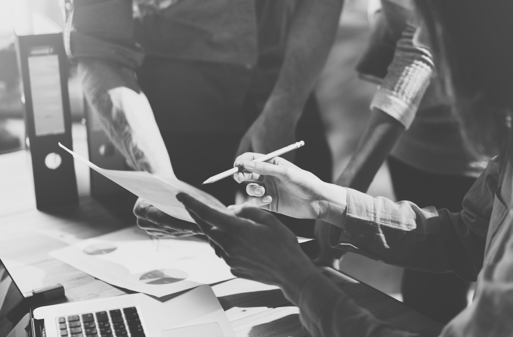 business woman reviewing insurance document with other workers 