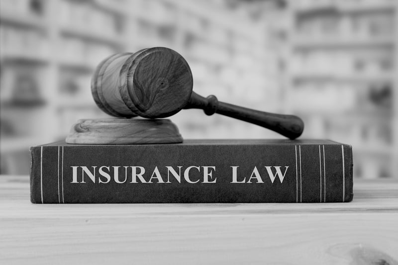 insurance law book on desk with mallet resting on top