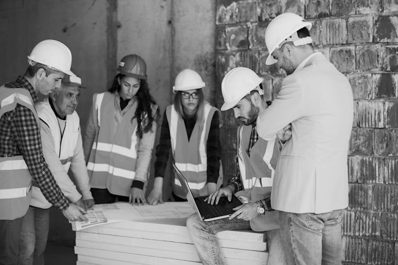 construction team gathered around to discuss insurance planning