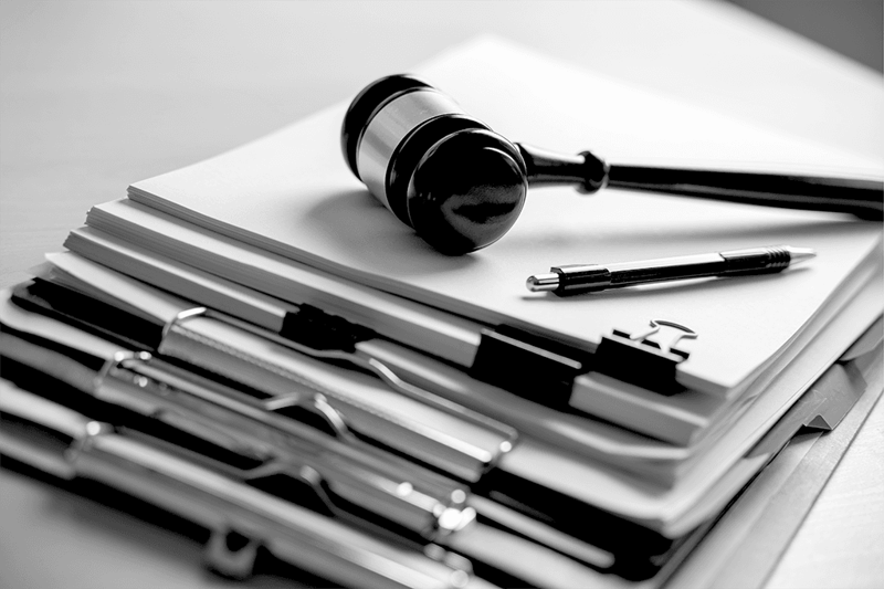 gavel on a pile of reports and clipboards with documents