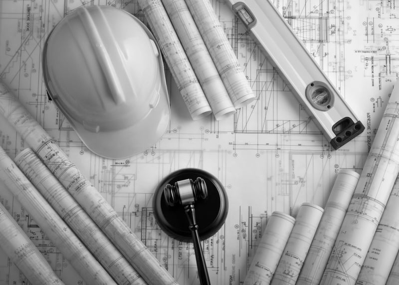 construction documents and design plans with hardhat and mallet