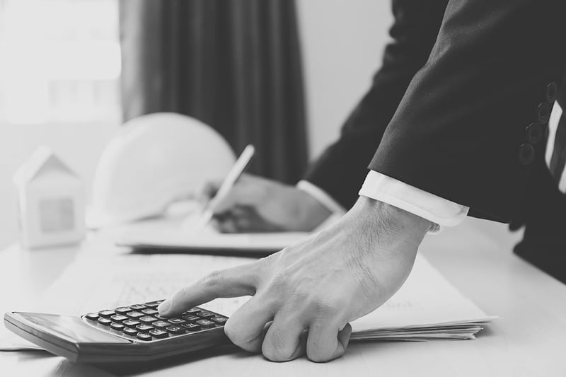 business man using calculator and taking notes at a desk