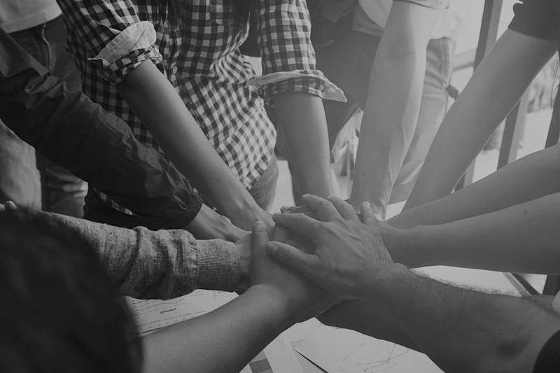 diverse group of business team members putting hands together