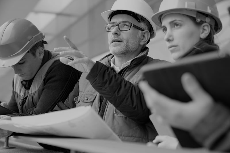 group of three construction workers analyzing jobsite