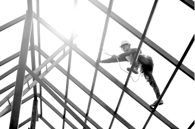 construction worker climbing a glass ceiling with safety harness at a jobsite