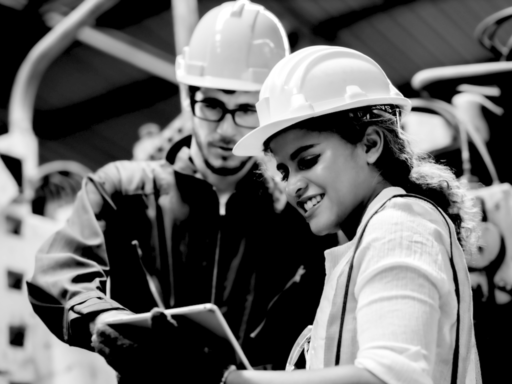 Construction woman and coworker discussing project with clipboard on project site 