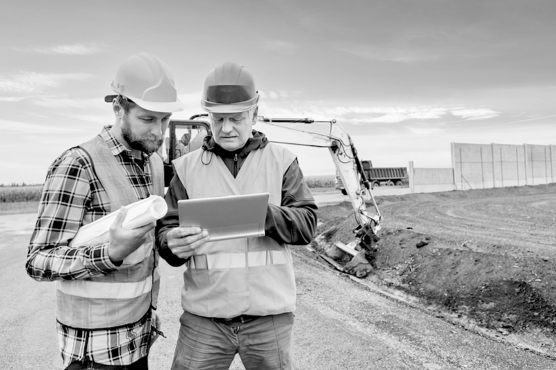 two construction workers reviewing information on a tablet